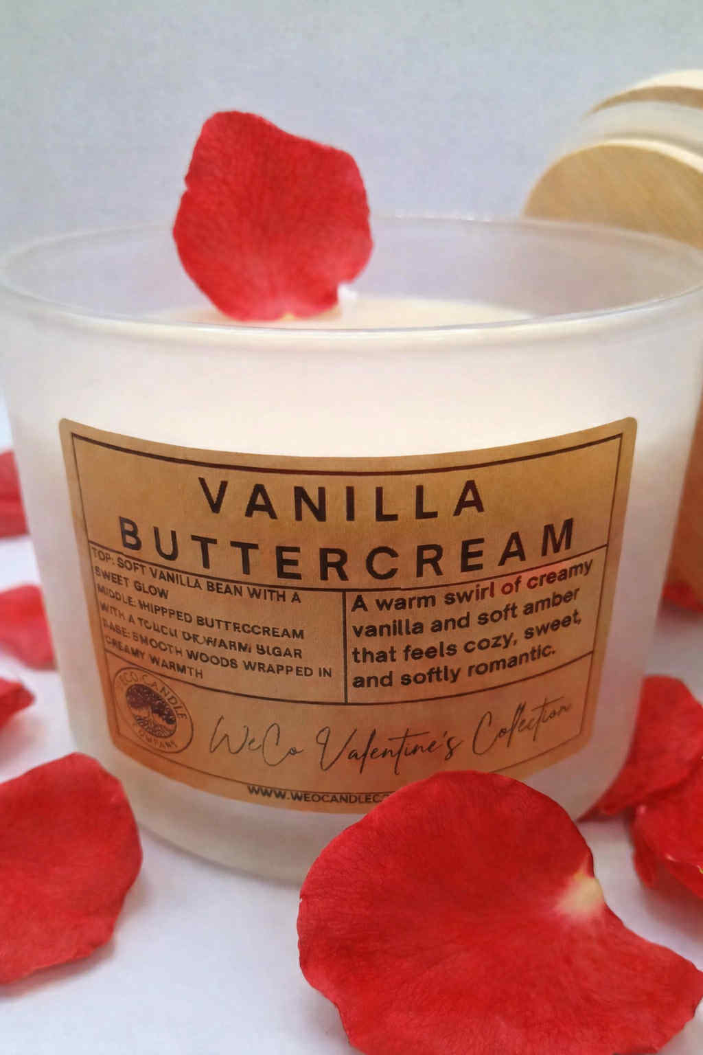Vanilla buttercream candle with red rose petals on a white background